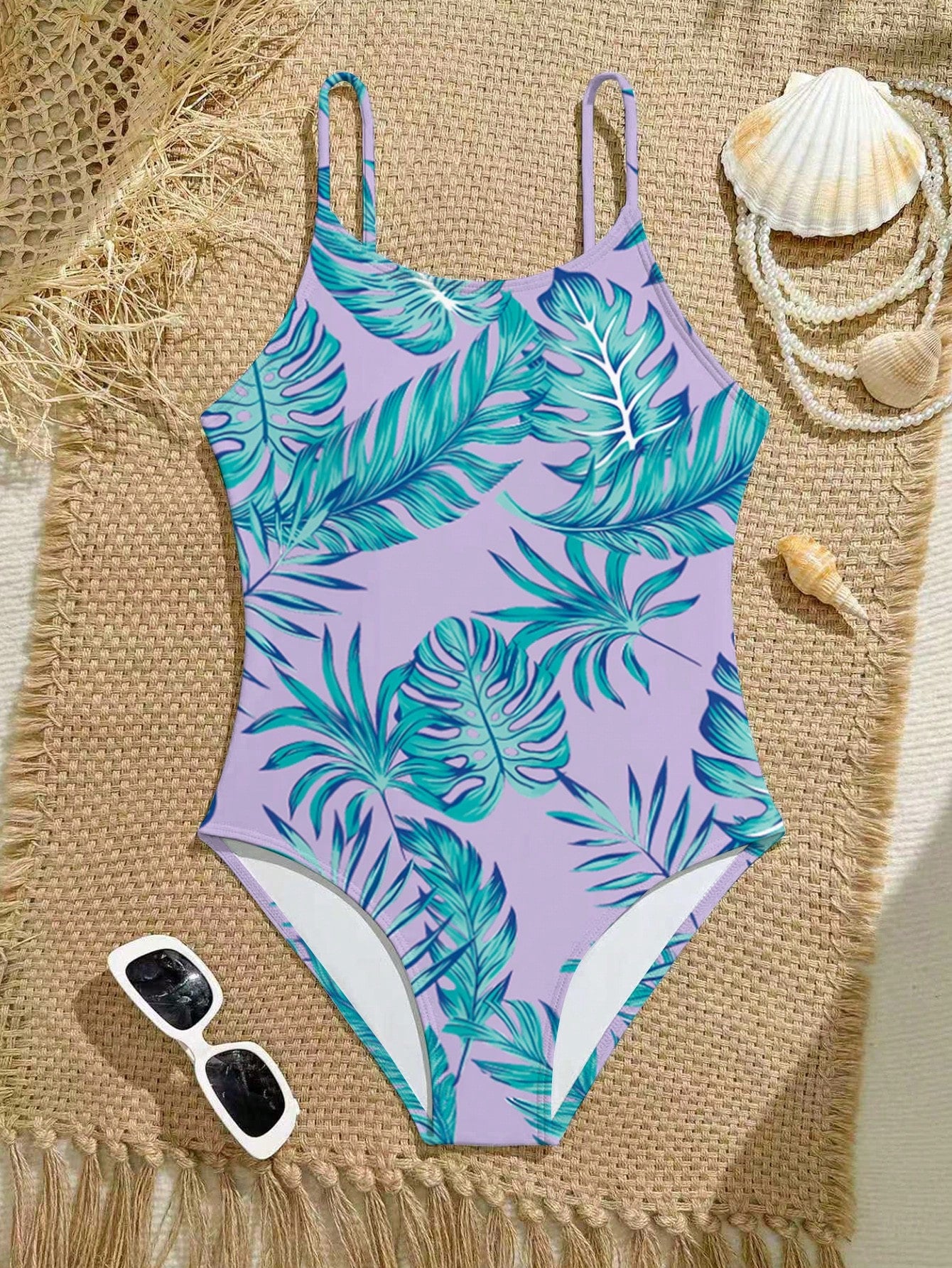 Tween girls one-piece swimsuit with a floral plant print, spaghetti straps, and a mid-waist fit in black.