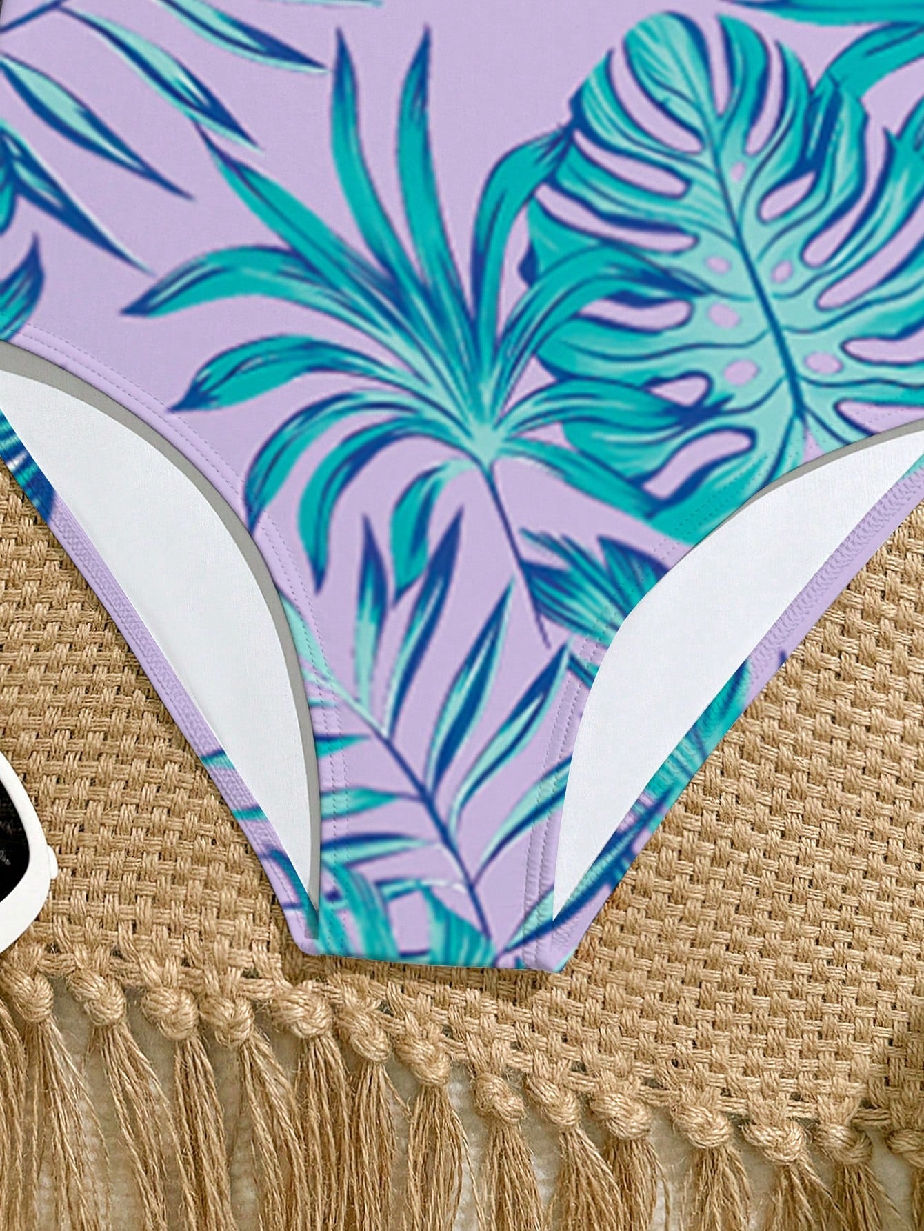 Tween girls one-piece swimsuit with a floral plant print, spaghetti straps, and a mid-waist fit in black.