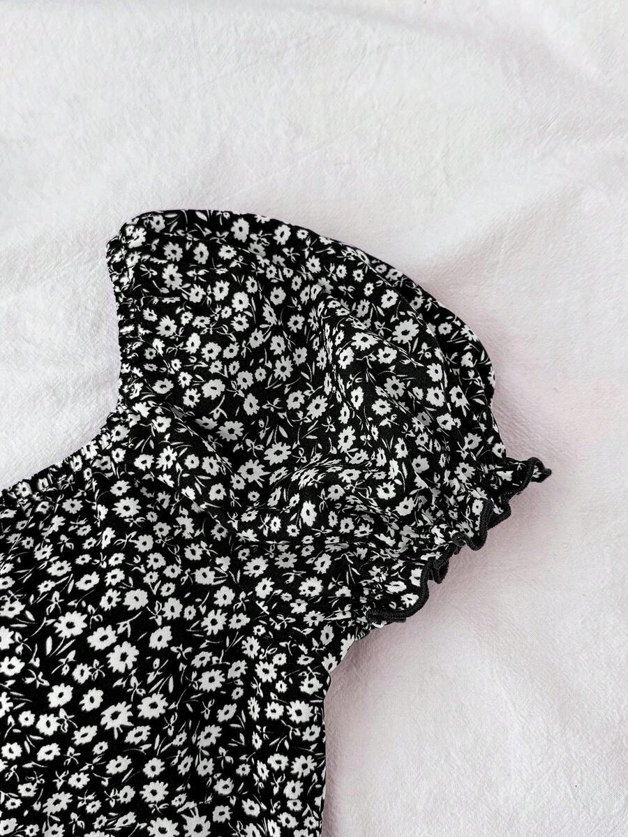 Black floral all-over print midi dress for tween girls featuring puff half sleeves, spaghetti strap neckline, and an A-line silhouette.