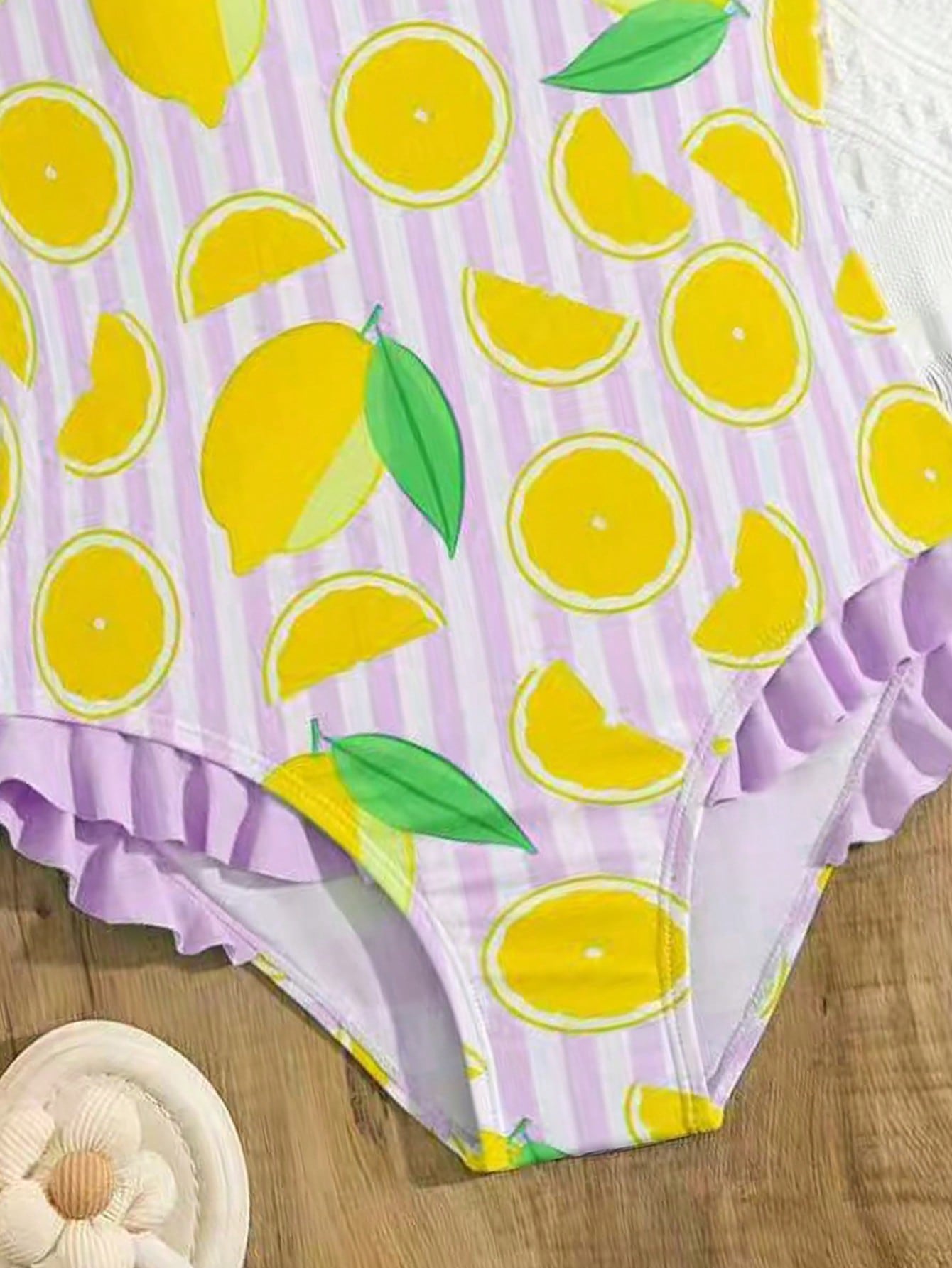 Tween girls purple one-piece swimsuit with lemon stripe pattern, spaghetti straps, ruffle detail, bow design, scoop neckline, and fitted swimwear shape