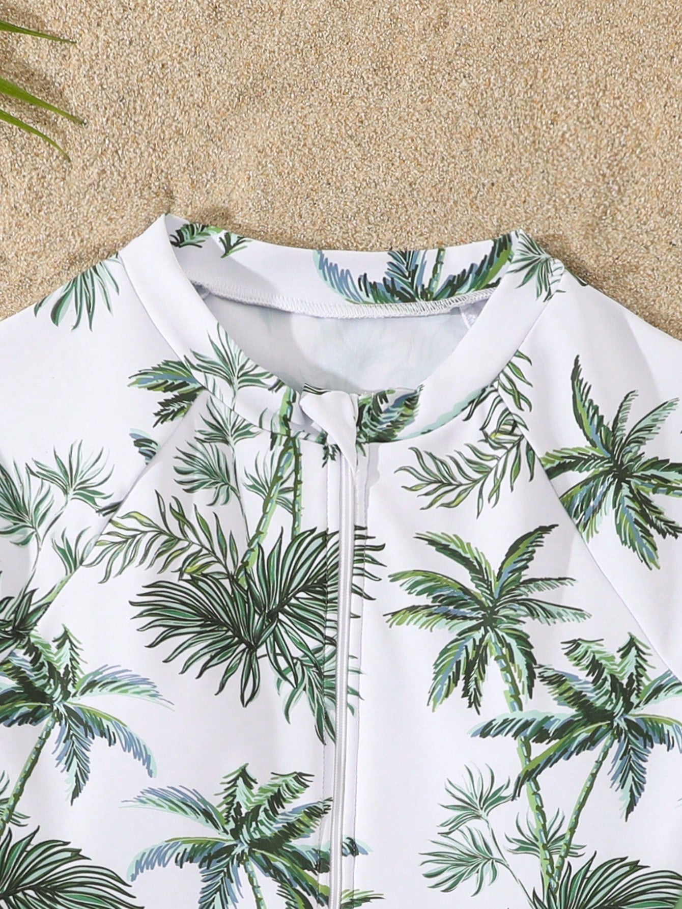 Tween girls one-piece rash guard swimsuit with long sleeves, high neck, front zipper, and ocean shell graphic print in a fitted style for beach, swimming, and vacation wear.