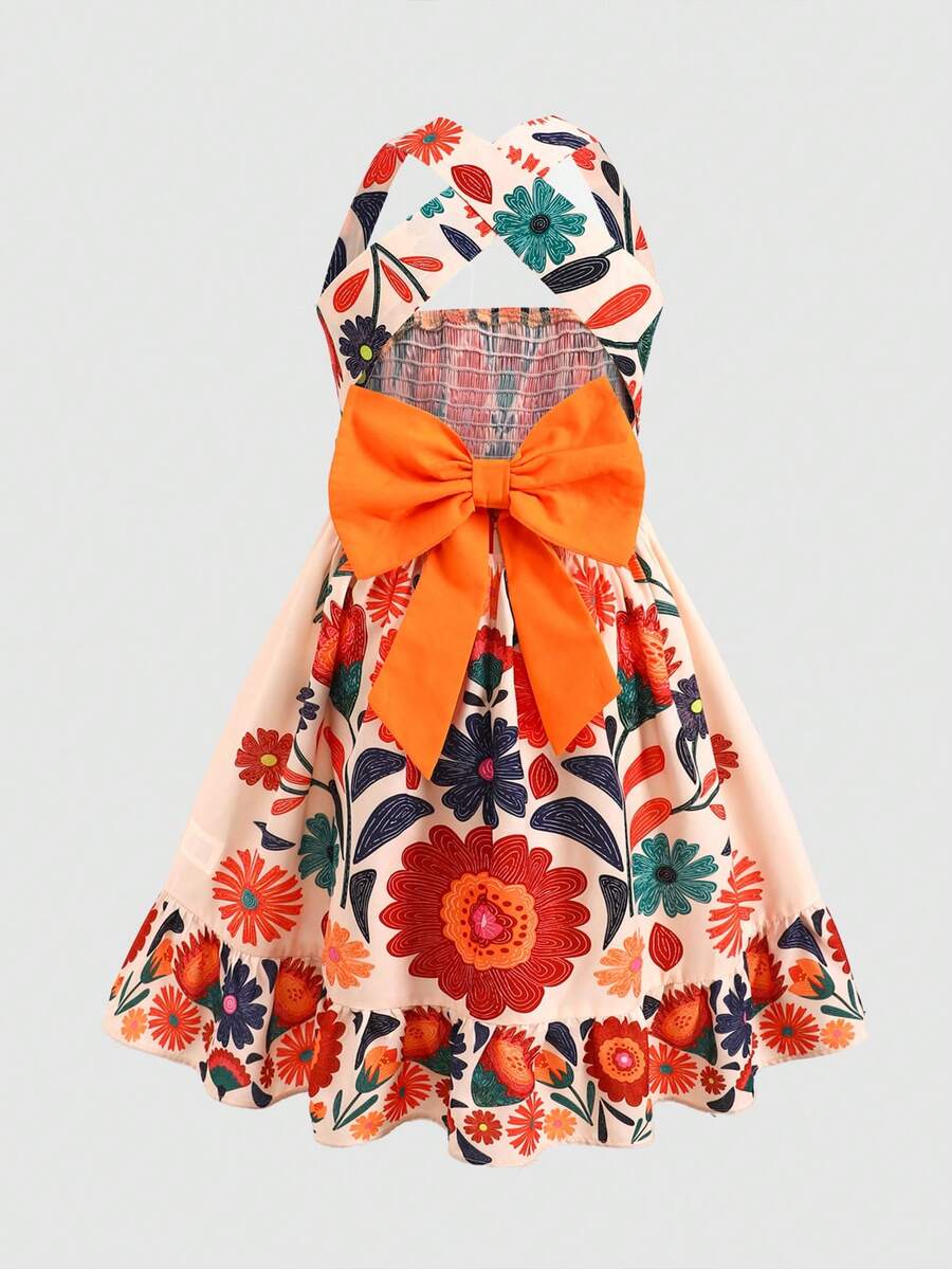 Pink sleeveless tween girls vacation dress with all-over fruit and vegetable print, strap neckline, belted high waist, cut-out detail, and flared ruffle hem.