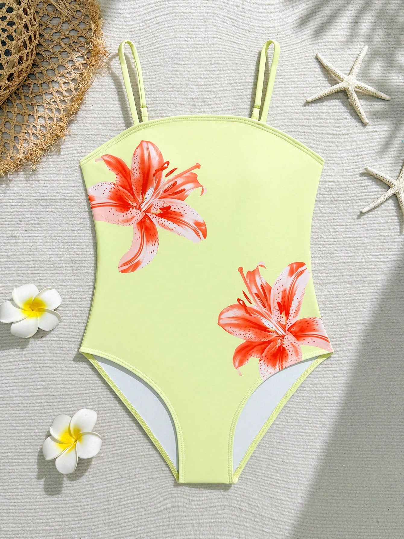 Tween girls one-piece swimsuit with a floral plant print, spaghetti straps, and a mid-waist fit in black.