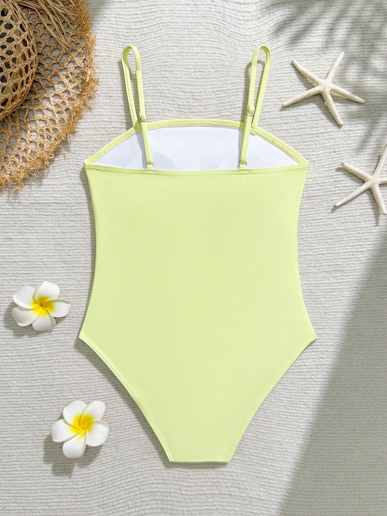Tween girls one-piece swimsuit with a floral plant print, spaghetti straps, and a mid-waist fit in black.