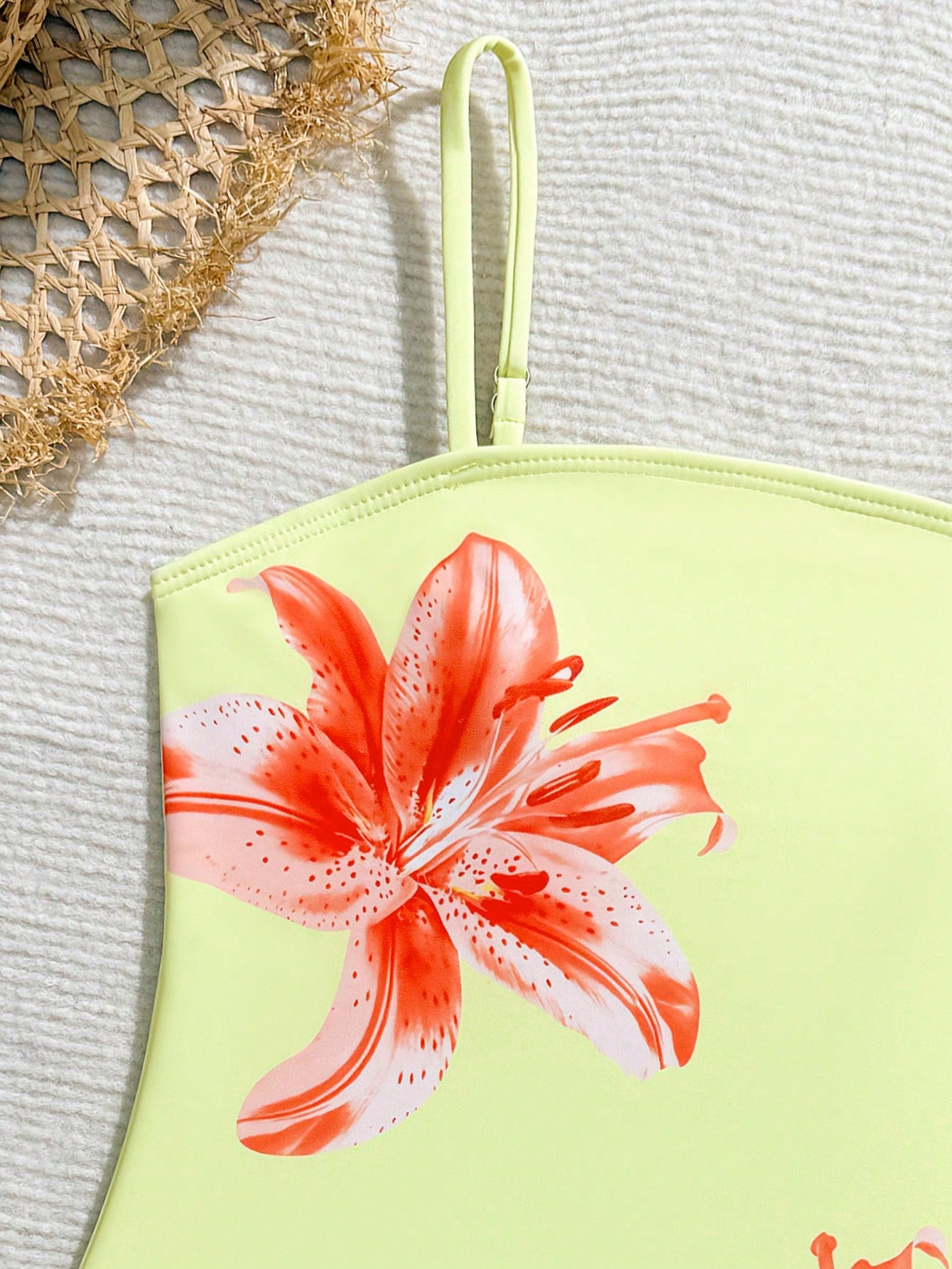 Tween girls one-piece swimsuit with a floral plant print, spaghetti straps, and a mid-waist fit in black.