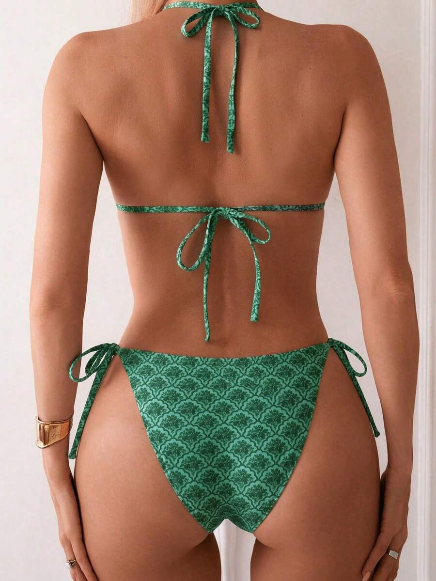 Women's black two-piece bikini set featuring a halter neck with a colorful sun pendant, triangle cups, and high-cut tie-side bottoms.