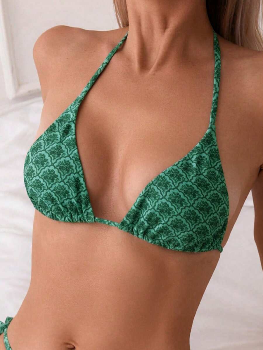 Women's black two-piece bikini set featuring a halter neck with a colorful sun pendant, triangle cups, and high-cut tie-side bottoms.