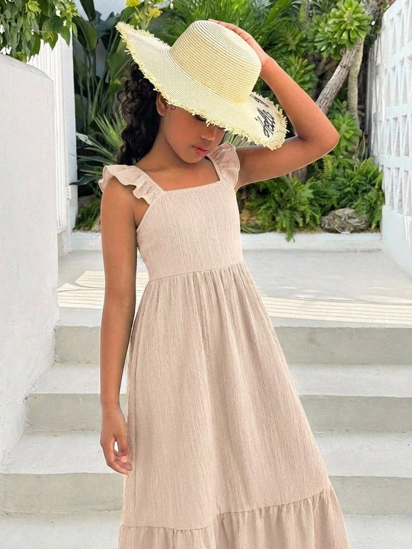 Tween girl multicolor floral vacation dress with square neck, ruffle details, shirred bodice, sleeveless A-line shape, high waist, and flounce hem.