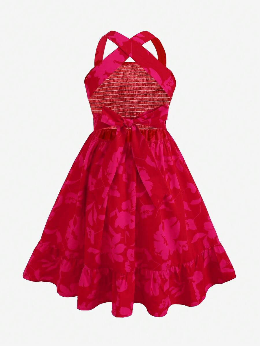 Pink sleeveless tween girls vacation dress with all-over fruit and vegetable print, strap neckline, belted high waist, cut-out detail, and flared ruffle hem.