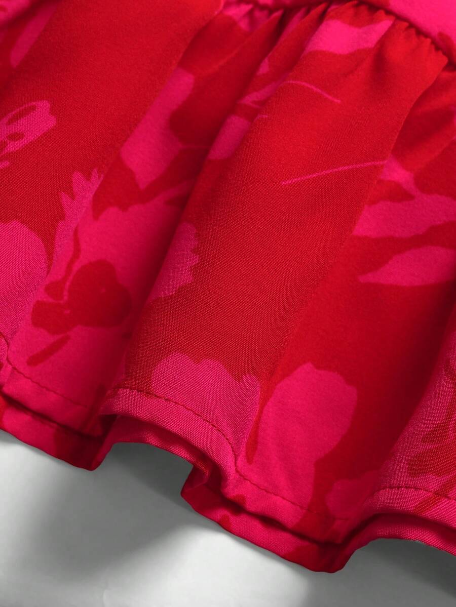 Pink sleeveless tween girls vacation dress with all-over fruit and vegetable print, strap neckline, belted high waist, cut-out detail, and flared ruffle hem.
