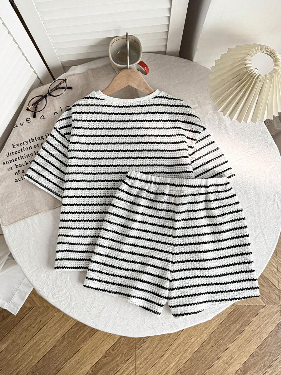 Tween girl wearing a black and white striped drop-shoulder crew neck t-shirt with bow embroidery paired with matching tie-waist shorts.