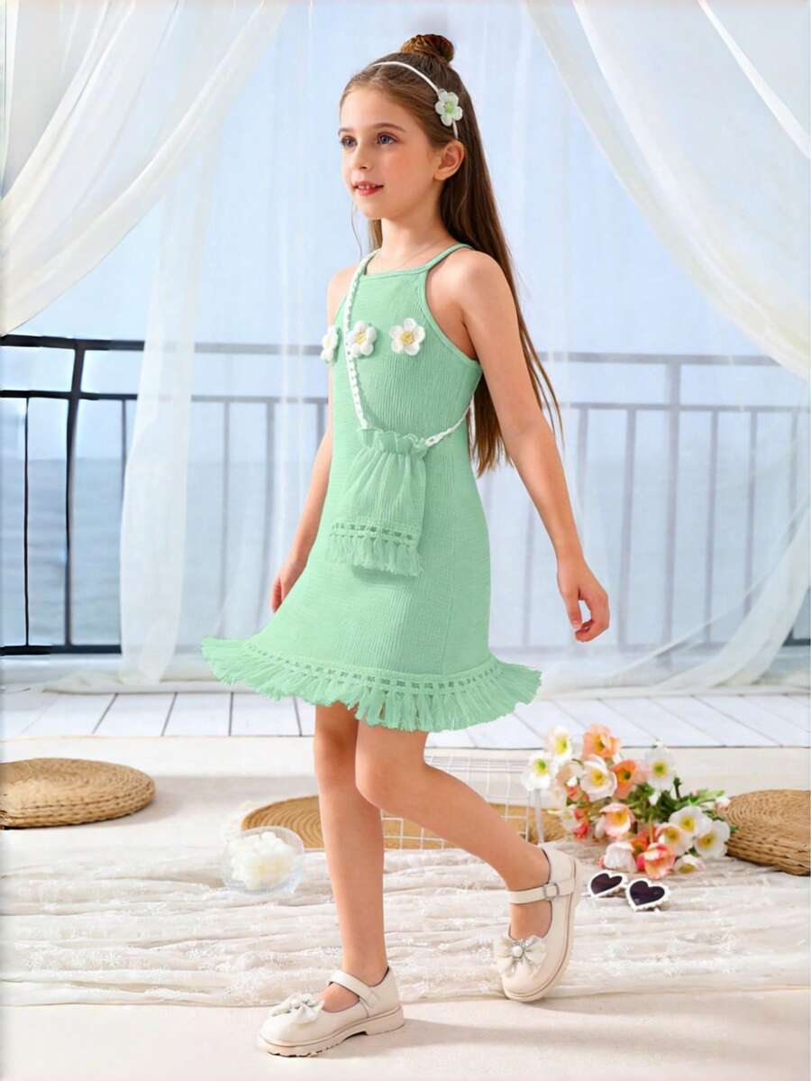 Girls' sleeveless summer midi dress with halter neckline, geometric pattern, applique and fringe details, shown with crossbody bag accessory with tassel decor