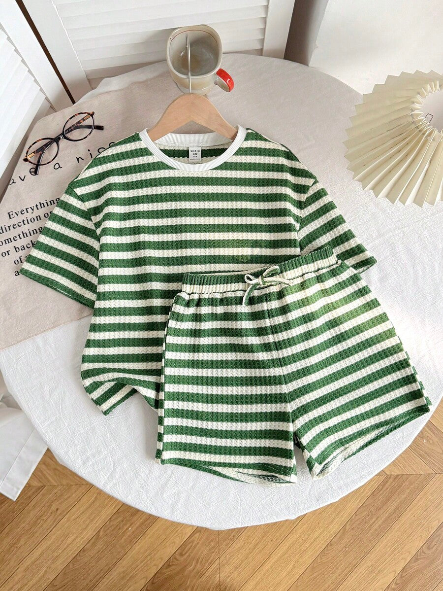 Tween girl wearing a black and white striped drop-shoulder crew neck t-shirt with bow embroidery paired with matching tie-waist shorts.