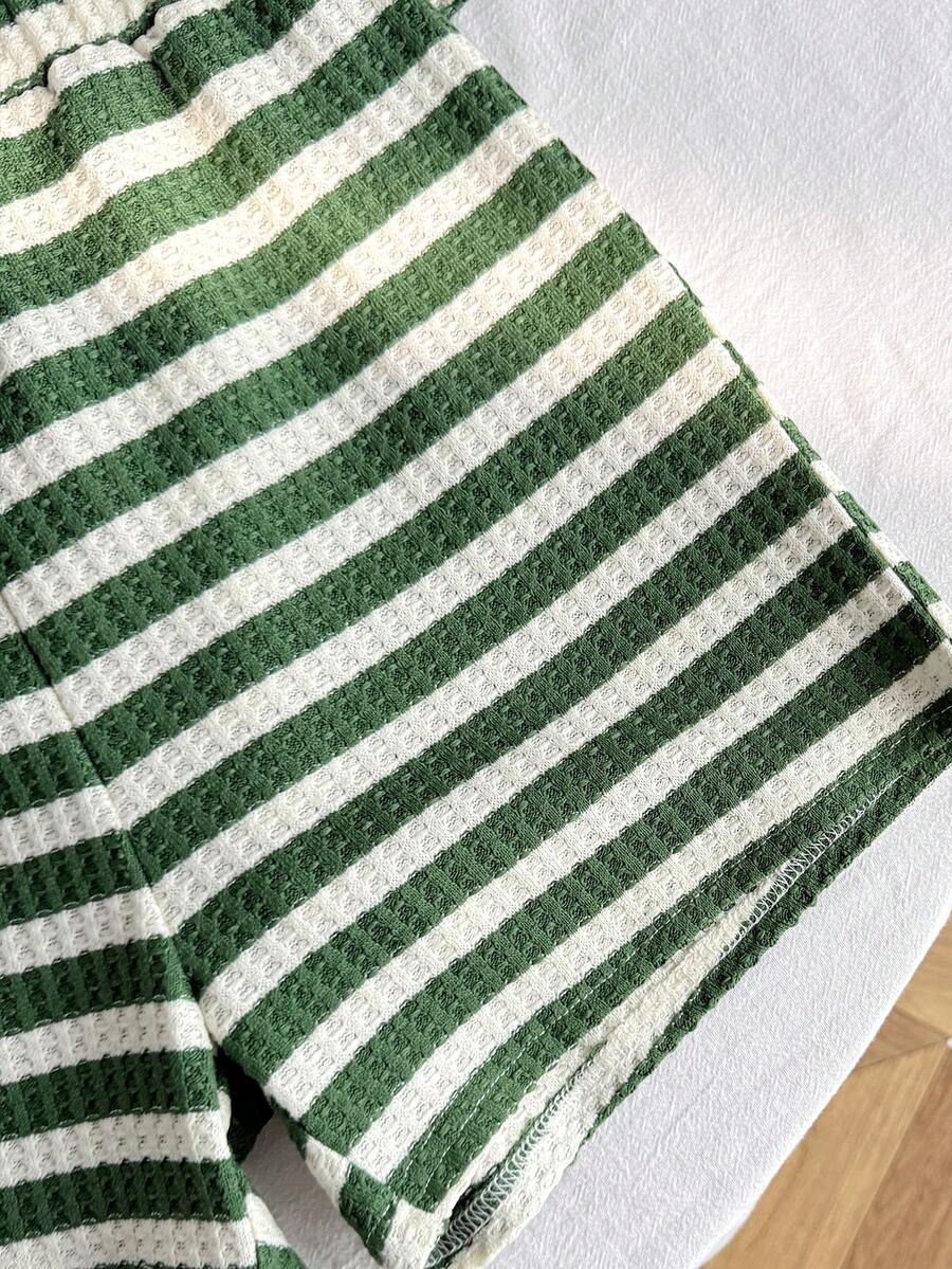 Tween girl wearing a black and white striped drop-shoulder crew neck t-shirt with bow embroidery paired with matching tie-waist shorts.