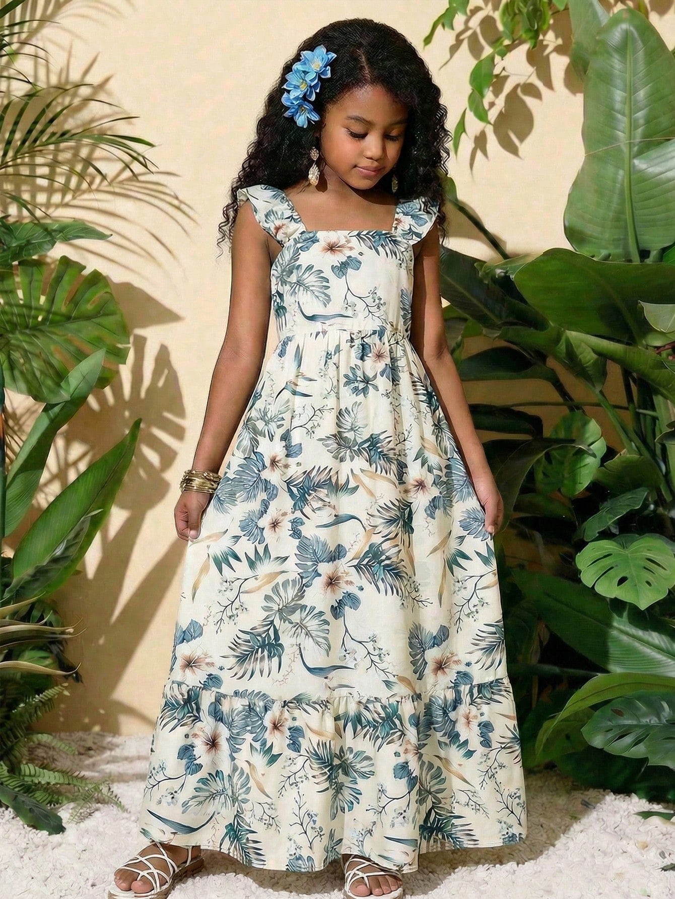 Blue floral print long vacation dress for tween girls featuring an A-line high waist silhouette with ruffle details and spaghetti straps.
