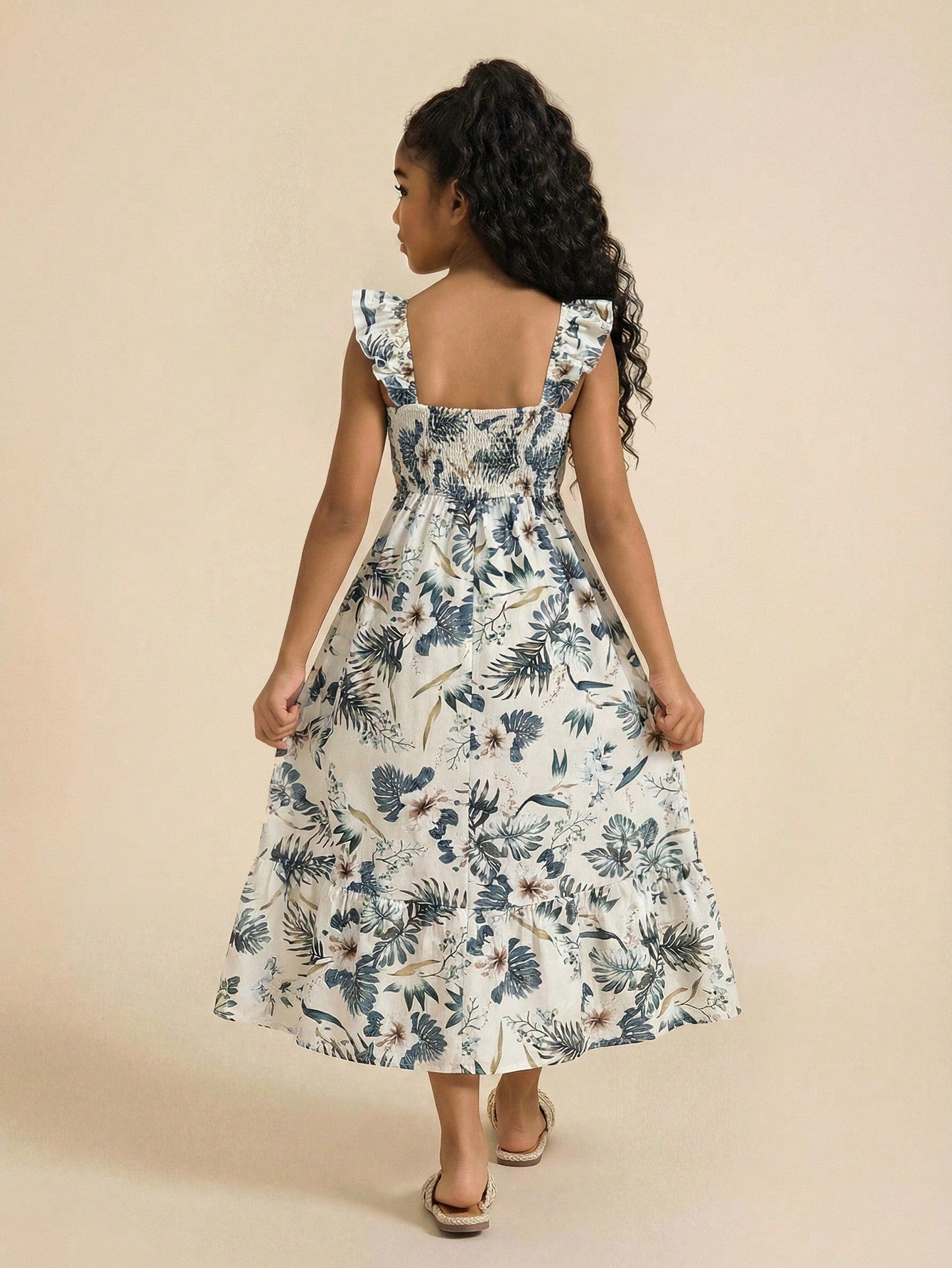 Tween girl multicolor floral vacation dress with square neck, ruffle details, shirred bodice, sleeveless A-line shape, high waist, and flounce hem.