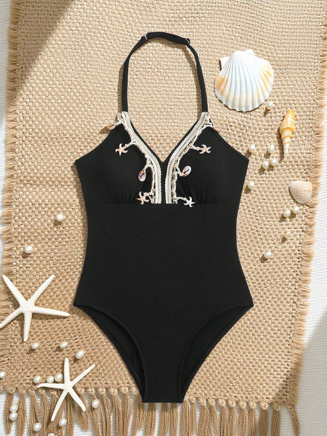 Black tween girls one-piece swimsuit with halter neckline, shell embroidery detail, ribbed texture, and mid-waist bottom for beach, swimming, and vacation wear.