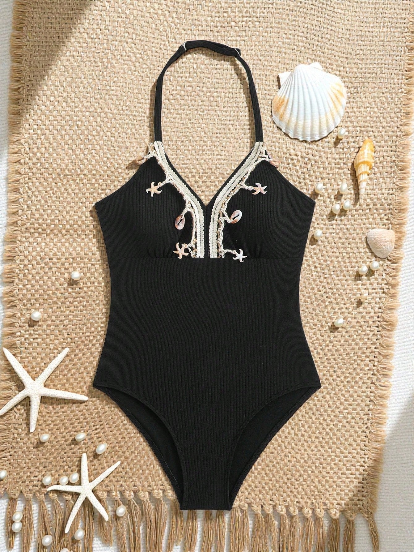 Black tween girls one-piece swimsuit with halter neckline, shell embroidery detail, ribbed texture, and mid-waist bottom for beach, swimming, and vacation wear.