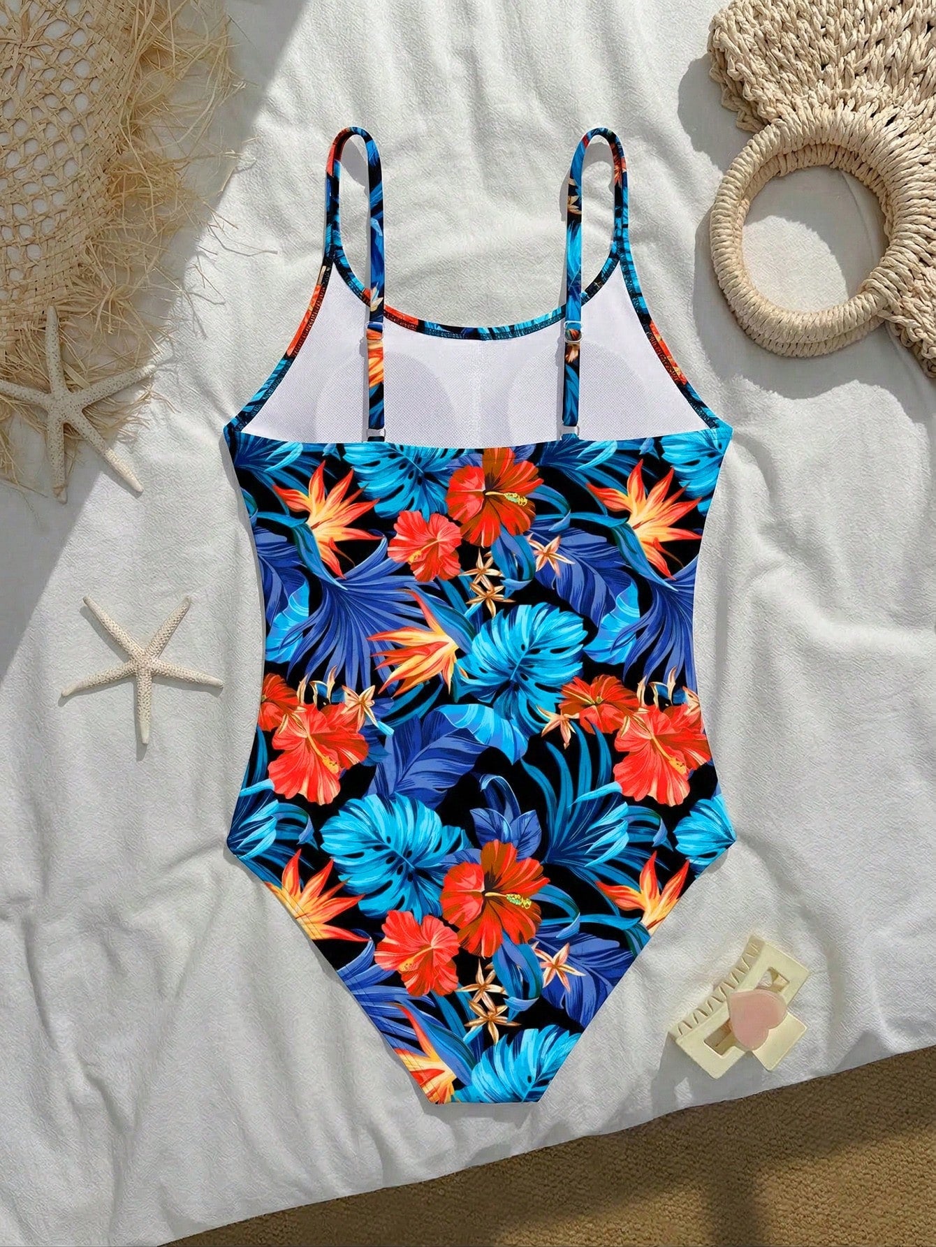 Tween girls one-piece swimsuit with a floral plant print, spaghetti straps, and a mid-waist fit in black.