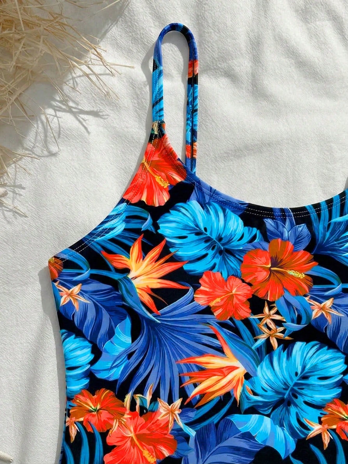 Tween girls one-piece swimsuit with a floral plant print, spaghetti straps, and a mid-waist fit in black.