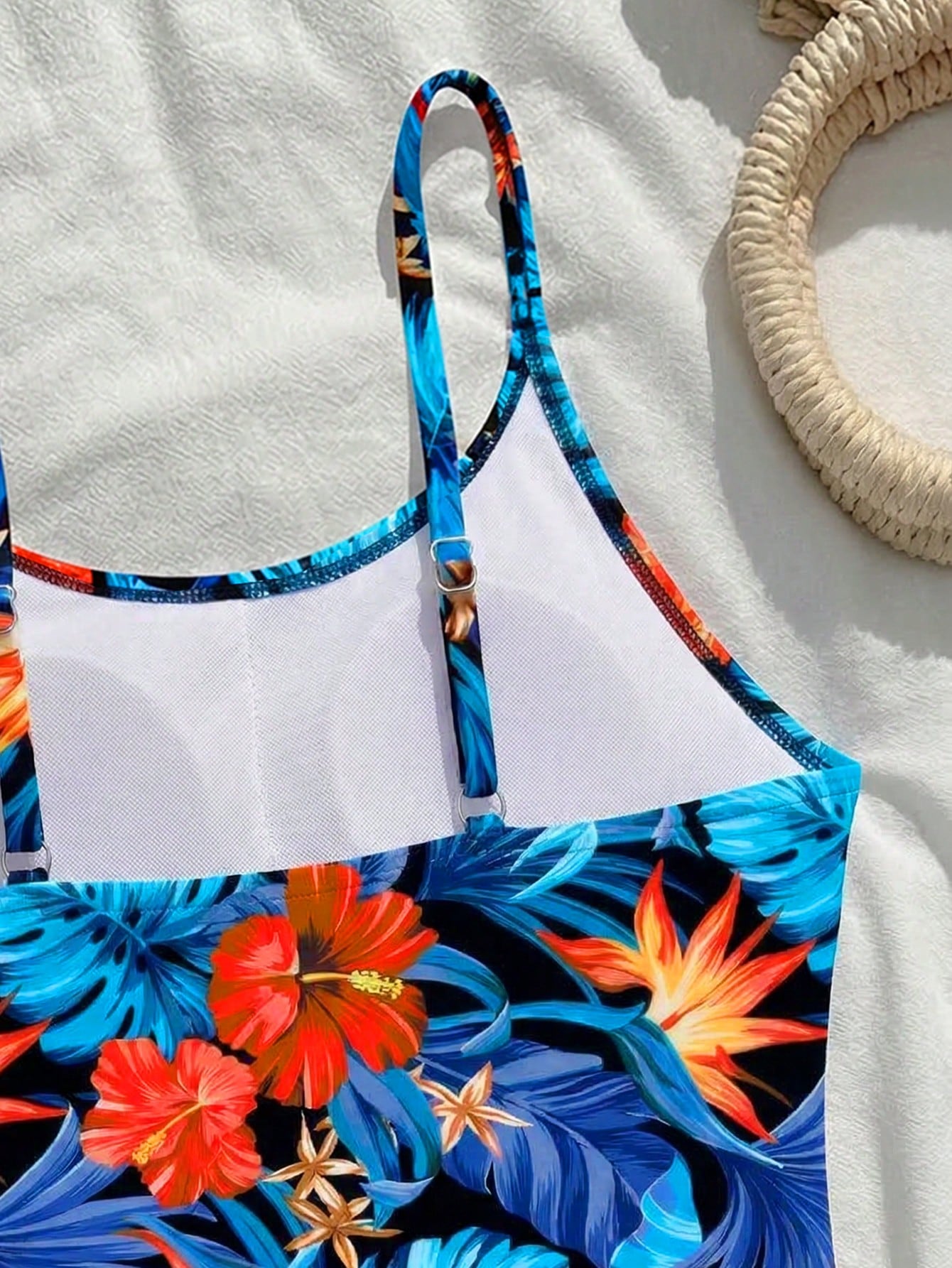 Tween girls one-piece swimsuit with a floral plant print, spaghetti straps, and a mid-waist fit in black.