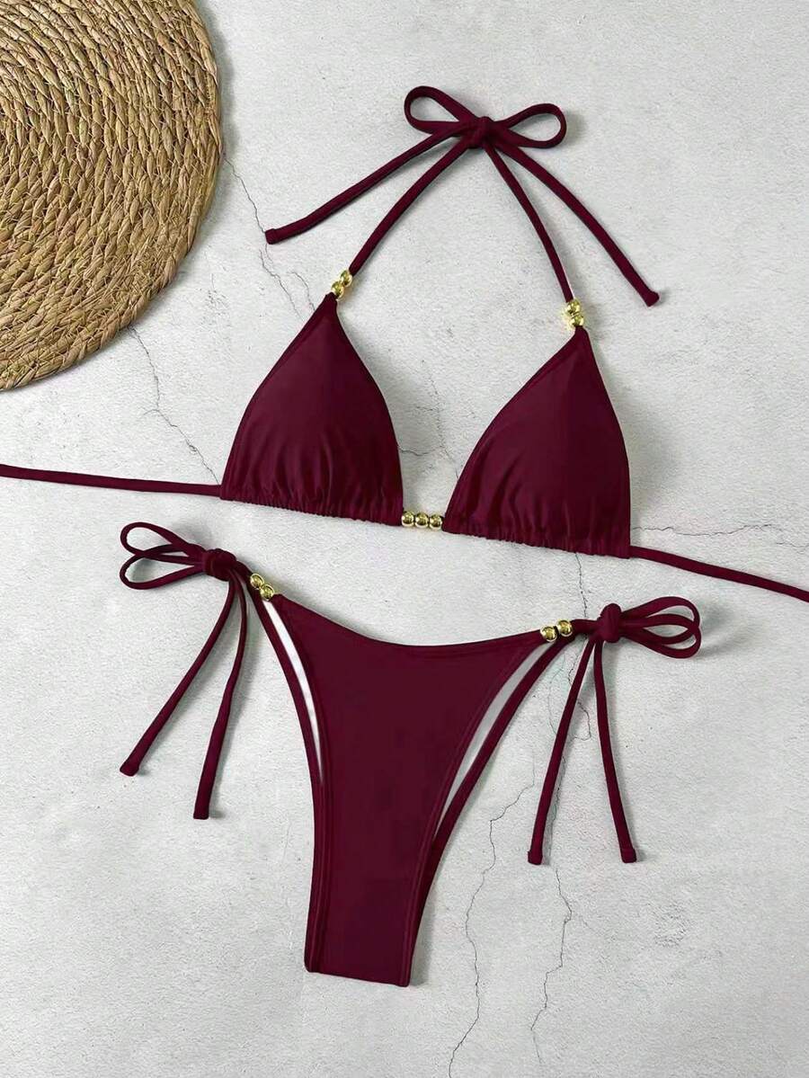 Women's black halter bikini set featuring triangle cups with gold bead decor and tie-back closure