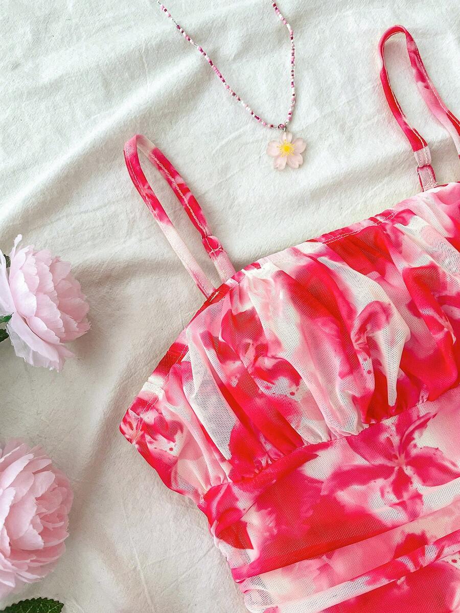Tween girl yellow mini sundress with large pink floral hibiscus print, spaghetti straps, high waist, flared hem, and sleeveless cami style for summer beach wear