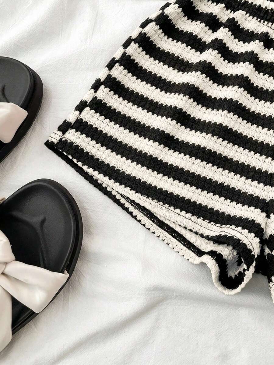 Tween girls black and white two-piece casual summer outfit featuring a rib-knit cropped top with round neck and matching shorts with contrast piping.