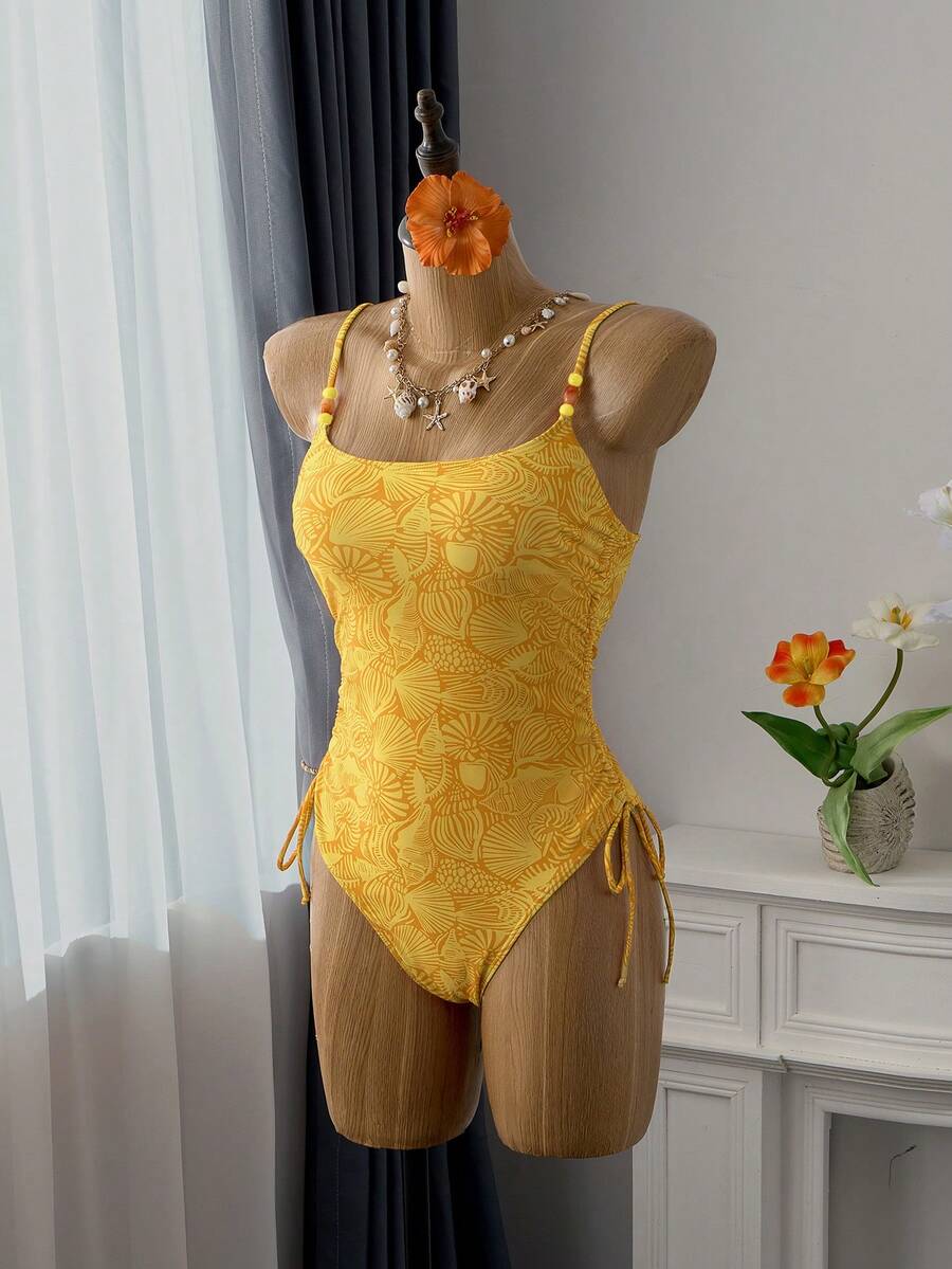 Women's blue backless one-piece swimsuit featuring spaghetti straps, wireless bra with removable padding, and drawstring details.