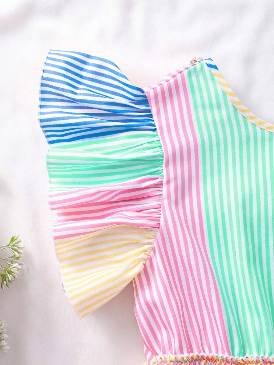 Tween girls blue short smock dress featuring flounce short sleeves, high waist flared hem, round neck, and front bow detail.