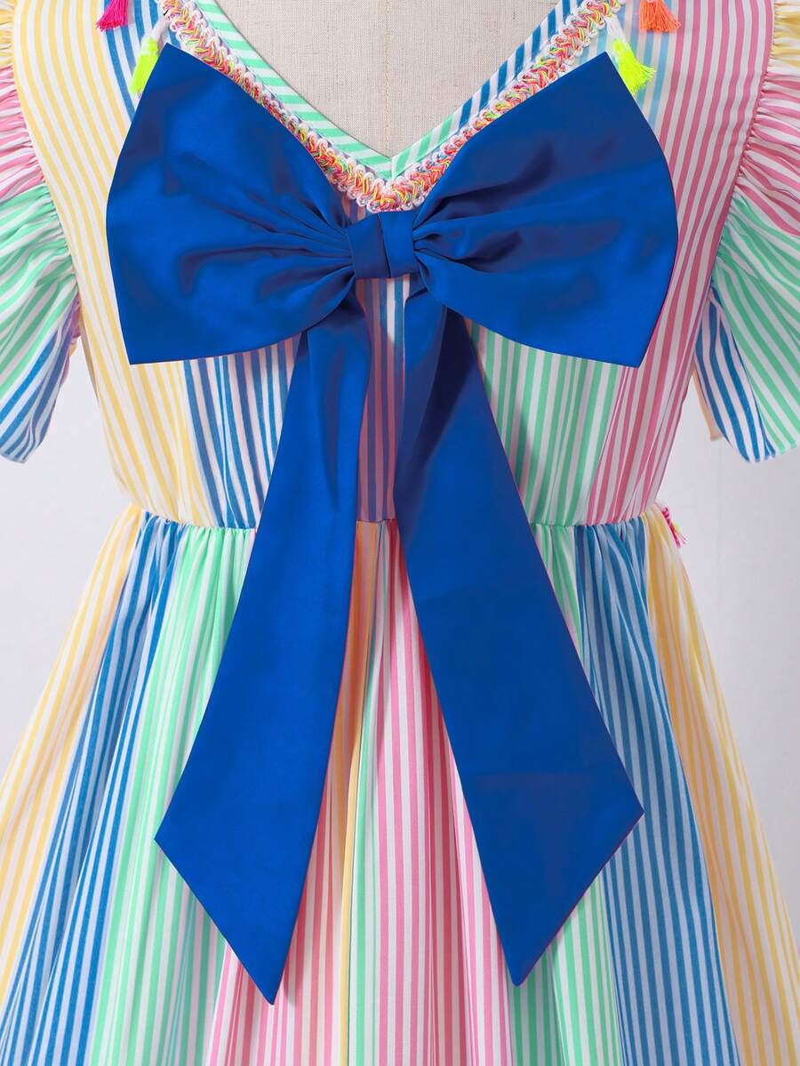 Tween girls blue short smock dress featuring flounce short sleeves, high waist flared hem, round neck, and front bow detail.