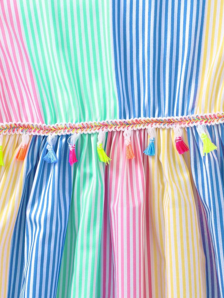 Tween girls blue short smock dress featuring flounce short sleeves, high waist flared hem, round neck, and front bow detail.