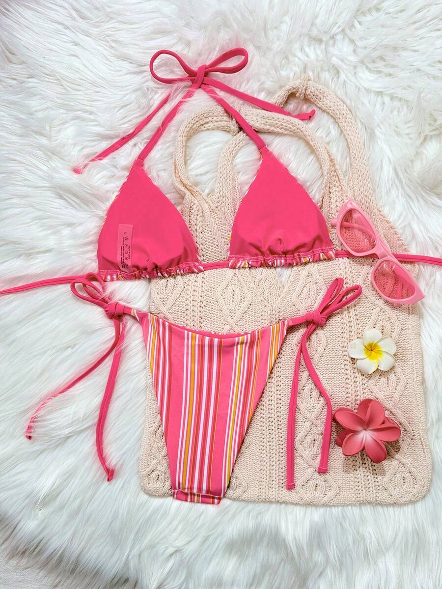 Women's black two-piece bikini set featuring a halter neck with a colorful sun pendant, triangle cups, and high-cut tie-side bottoms.