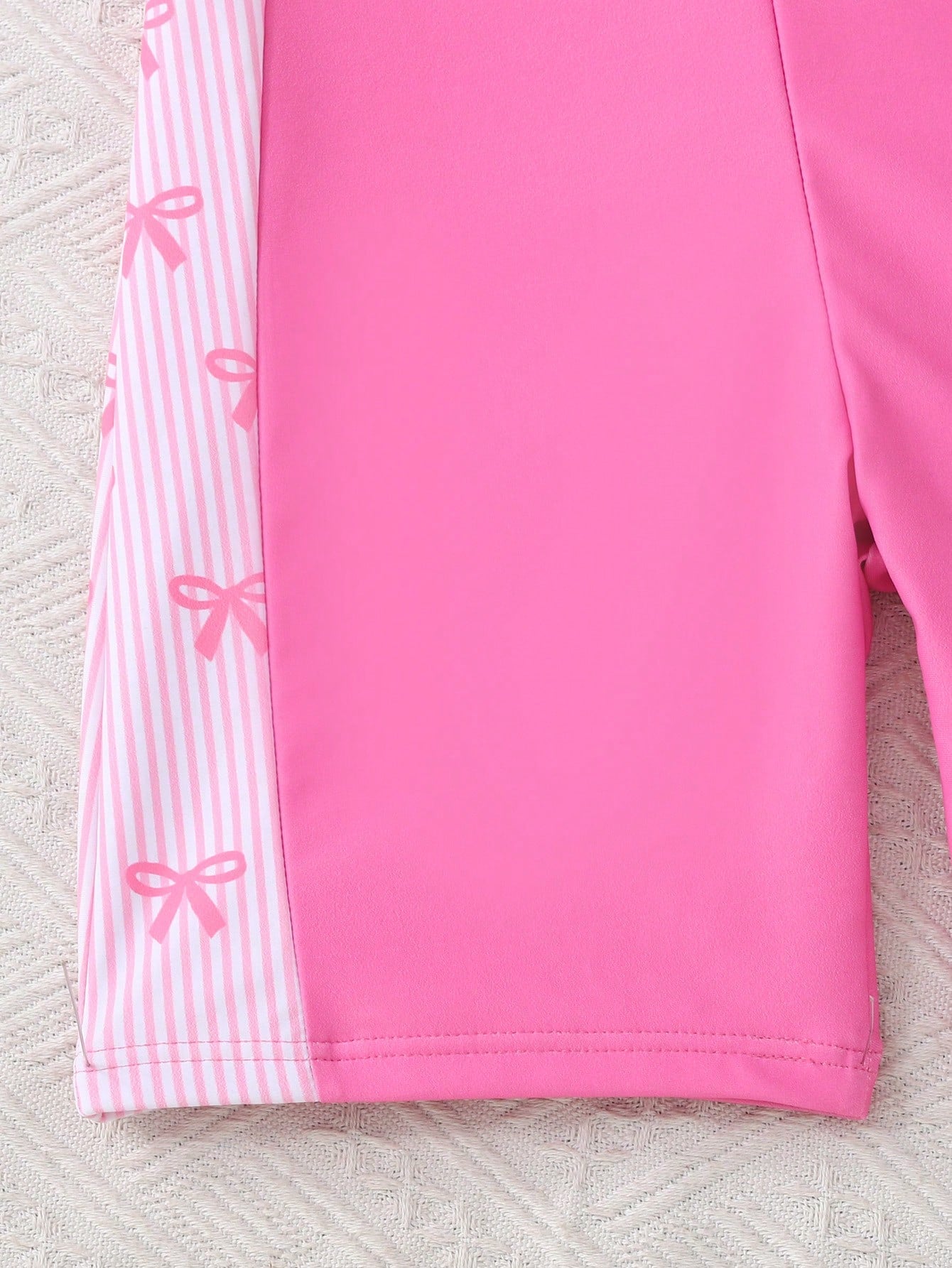 Black and white one-piece rashguard swimsuit for tween girls with short sleeves, high neck, zipper detail, fitted shape, and shorts-style bottom.