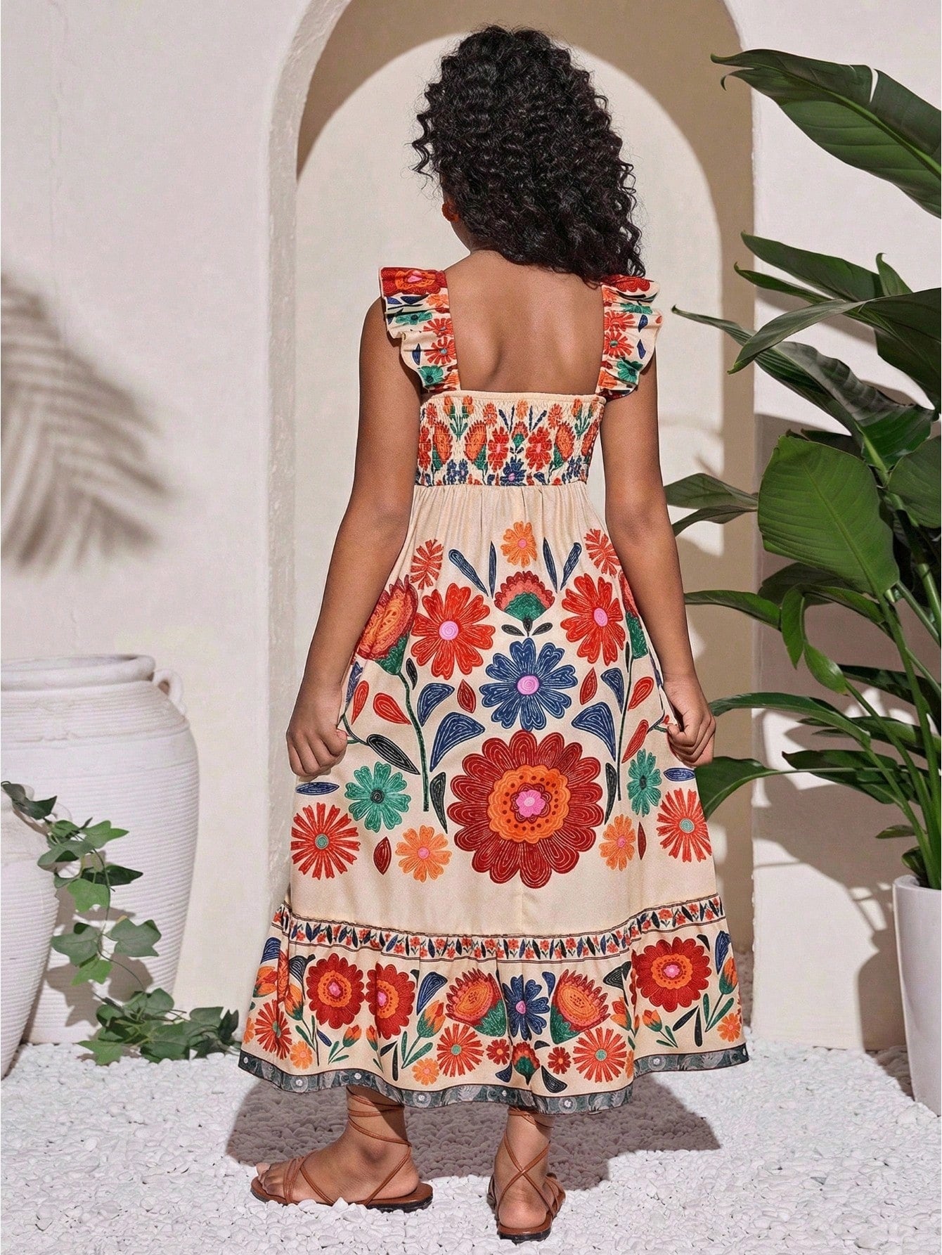 Tween girl multicolor floral vacation dress with square neck, ruffle details, shirred bodice, sleeveless A-line shape, high waist, and flounce hem.