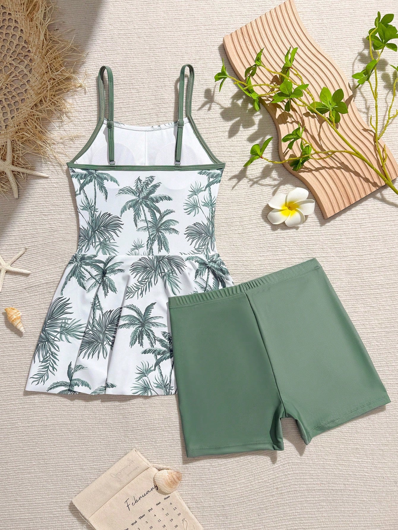 Tween girls black two-piece tankini swimwear set featuring a spaghetti strap sleeveless top with cutout detail and contrast piping, paired with short swim shorts.