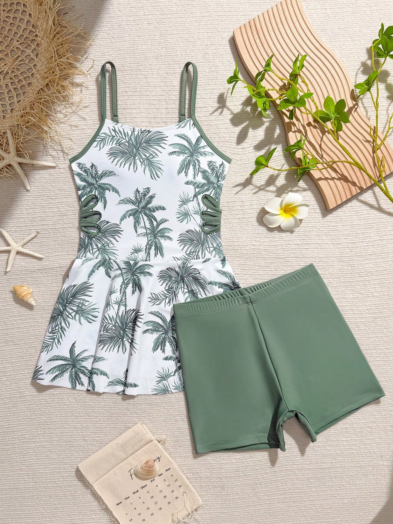 Tween girls black two-piece tankini swimwear set featuring a spaghetti strap sleeveless top with cutout detail and contrast piping, paired with short swim shorts.