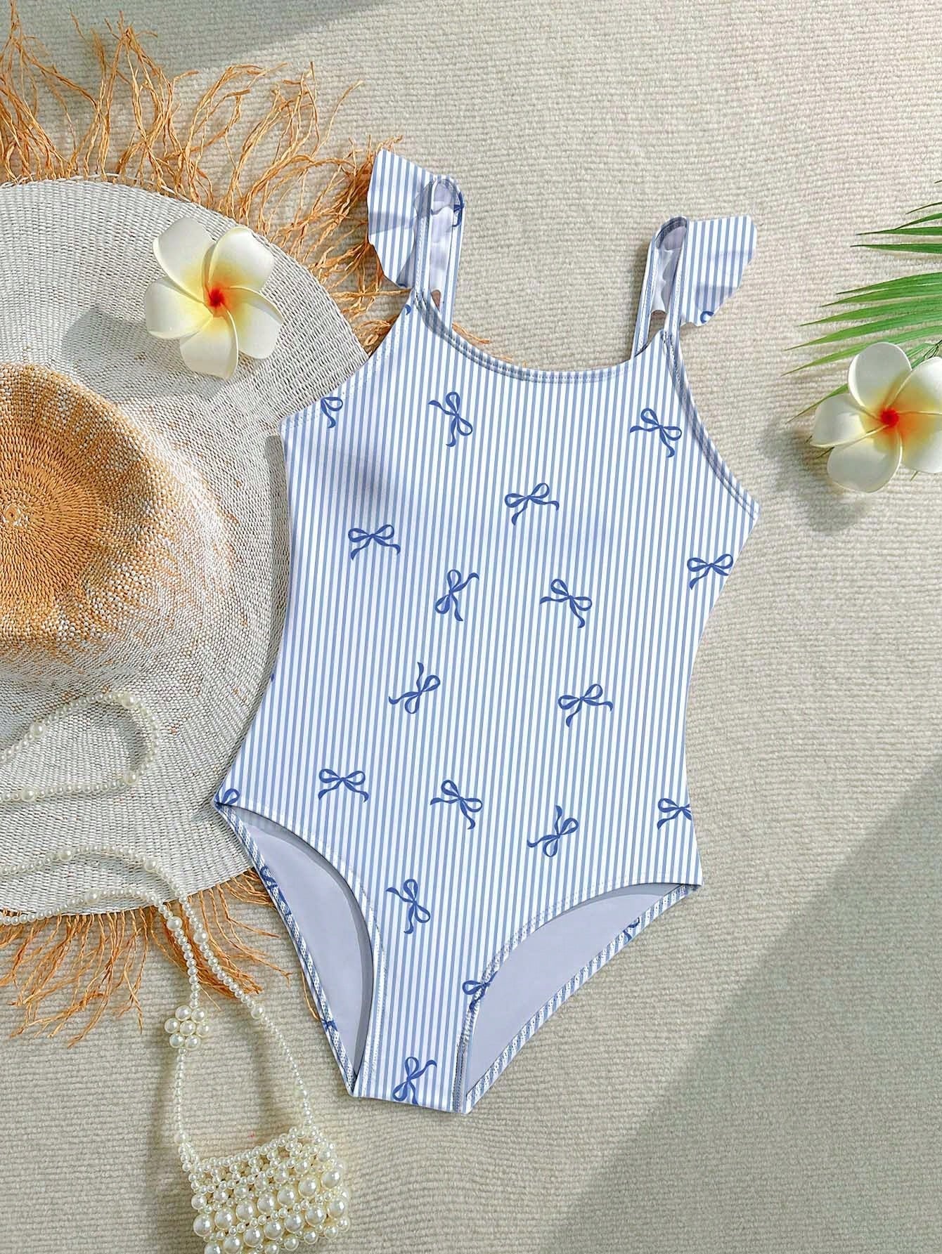 Tween girls one-piece swimsuit featuring an asymmetric neckline, pendant decor, plain design, wireless bra, high-cut bottom, and medium-stretch fabric.