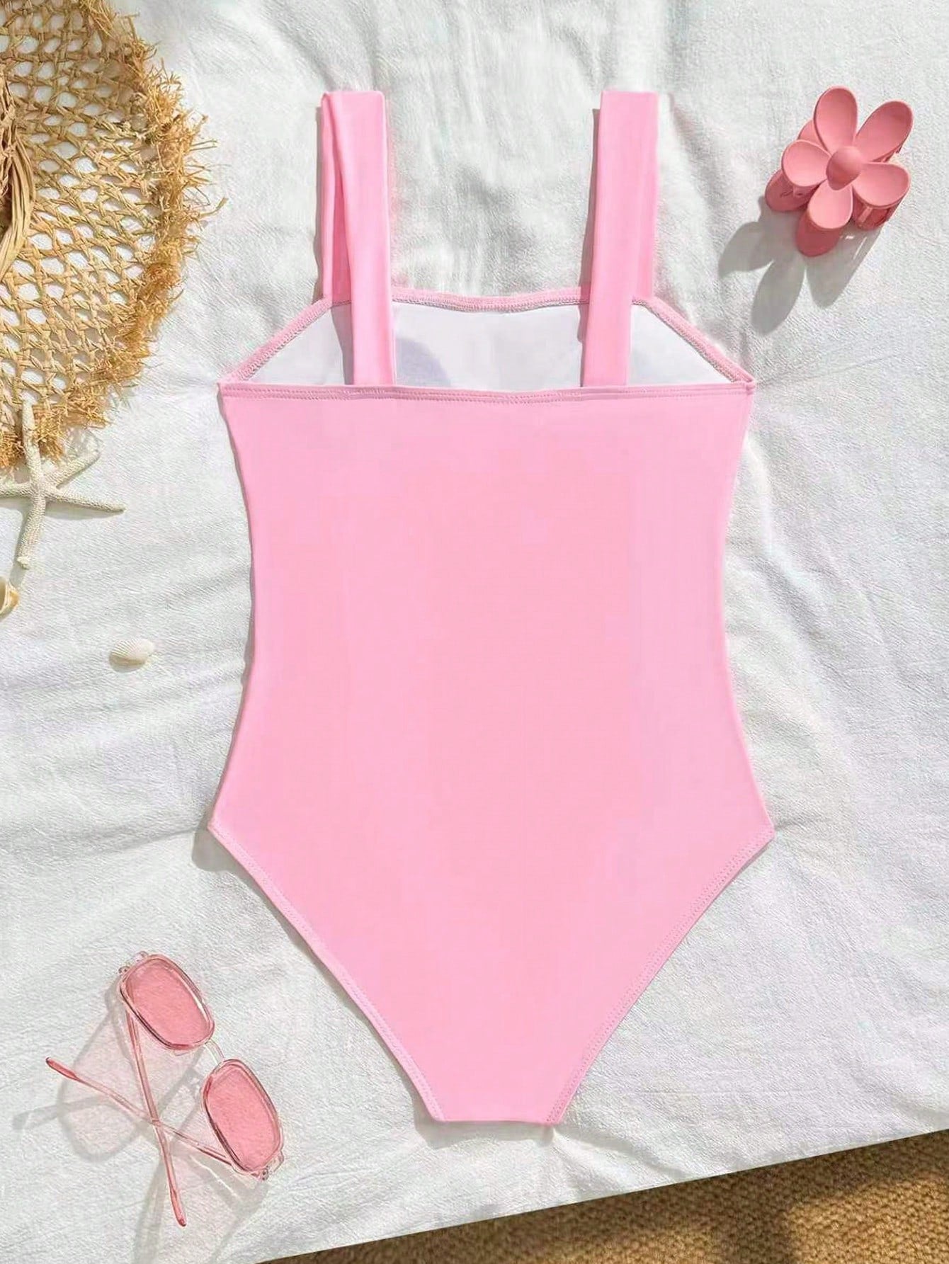 Tween girls one-piece swimsuit with a floral plant print, spaghetti straps, and a mid-waist fit in black.