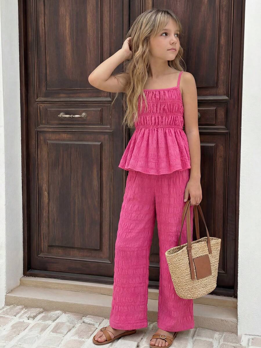 Tween girl wearing an apricot 2-piece outfit set featuring a shirred spaghetti strap short cami top and matching wide-leg long pants.