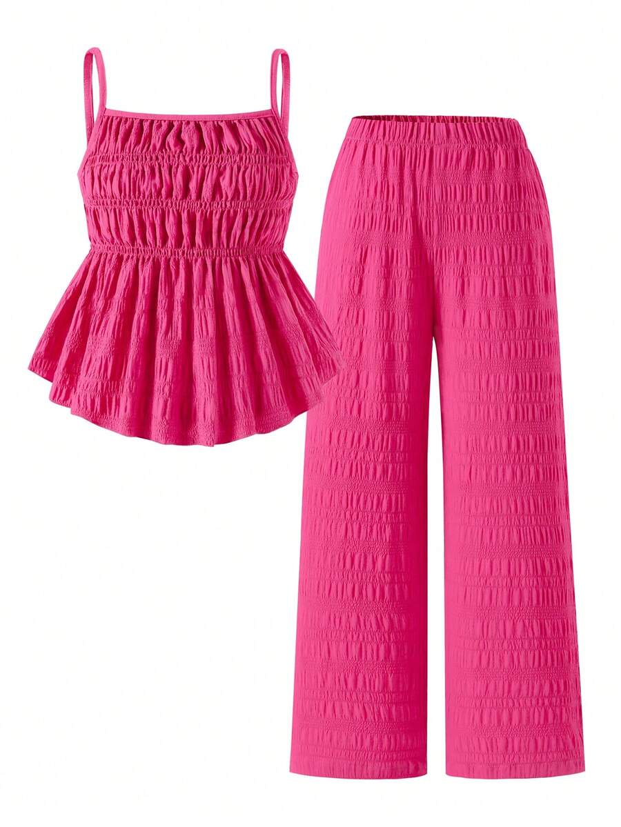 Tween girl wearing an apricot 2-piece outfit set featuring a shirred spaghetti strap short cami top and matching wide-leg long pants.