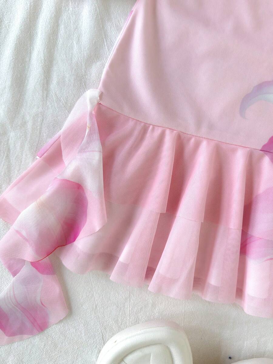 Tween girls sleeveless halter mini dress with ruffle tiered details, flounce hem, slim fit, lined body, and vacation-inspired plant print in khaki and pink tones.