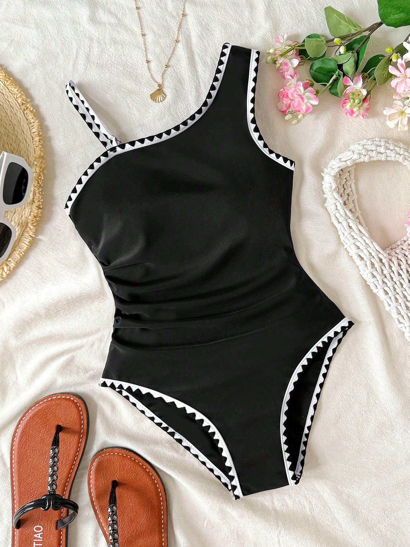 Tween girl one-piece swimsuit in brown polka dot geometric print with asymmetrical neckline, ruffle detail, cut-out design, and fitted mid-waist swim bottom.