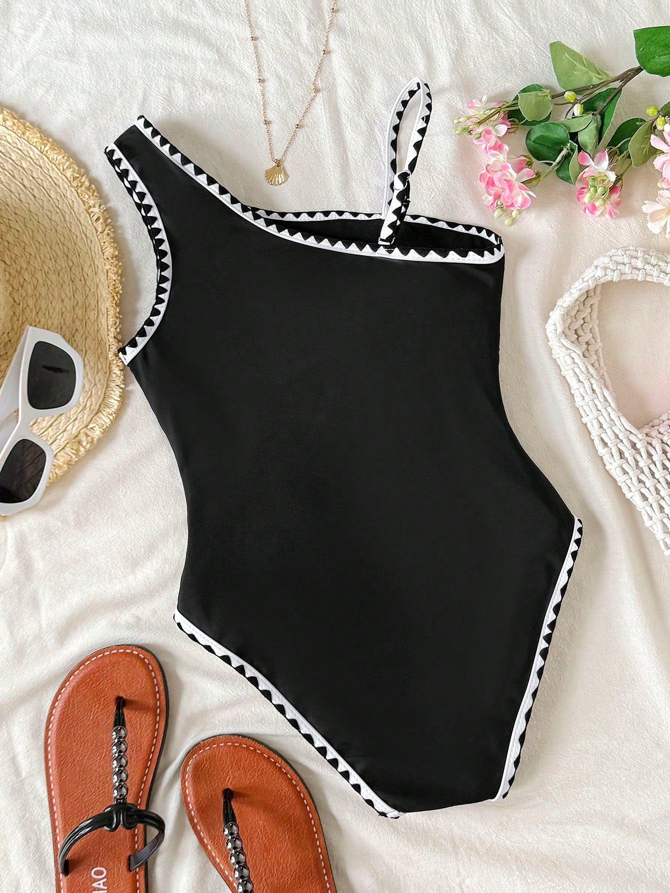 Tween girl one-piece swimsuit in brown polka dot geometric print with asymmetrical neckline, ruffle detail, cut-out design, and fitted mid-waist swim bottom.