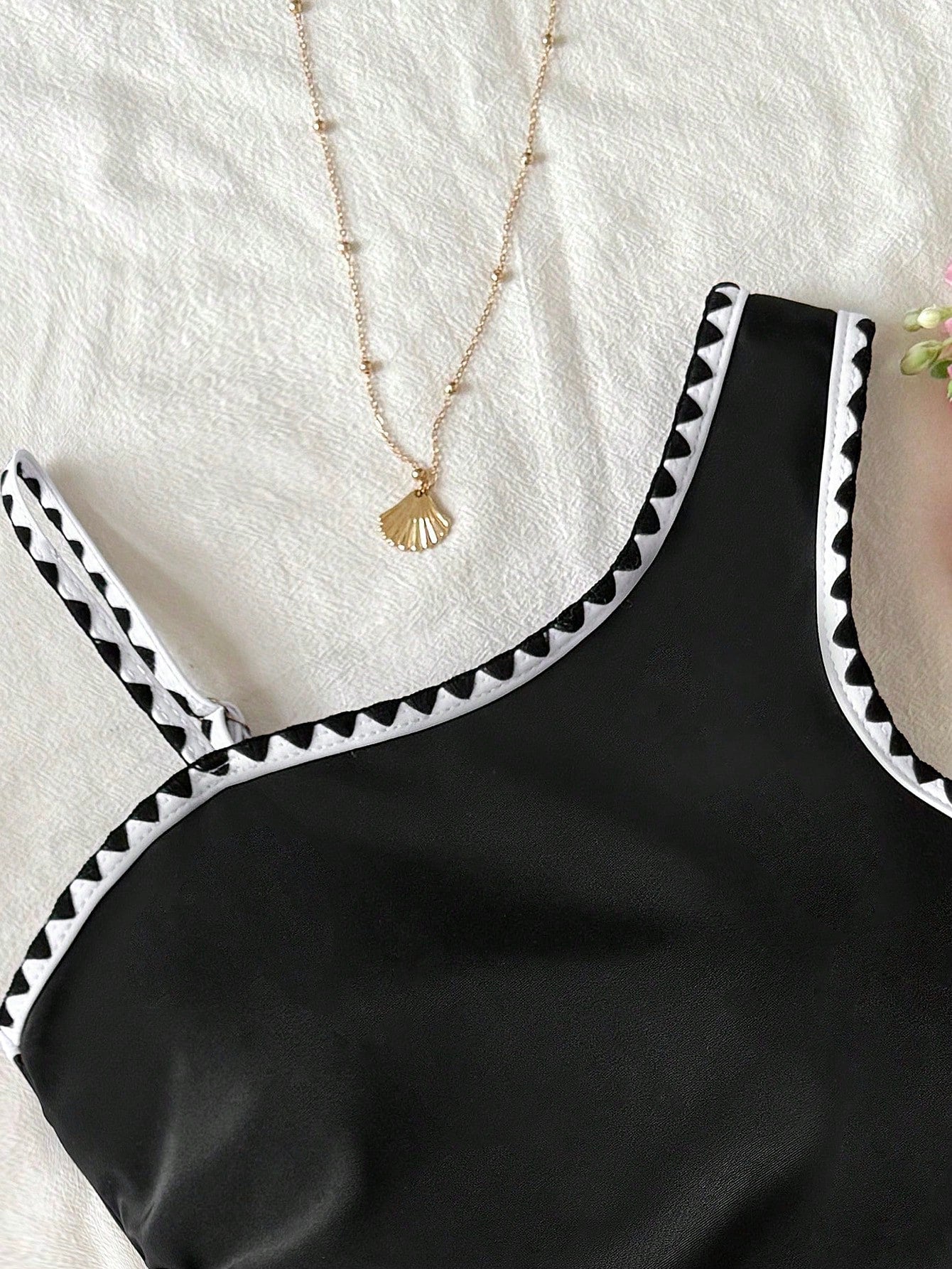 Tween girl one-piece swimsuit in brown polka dot geometric print with asymmetrical neckline, ruffle detail, cut-out design, and fitted mid-waist swim bottom.