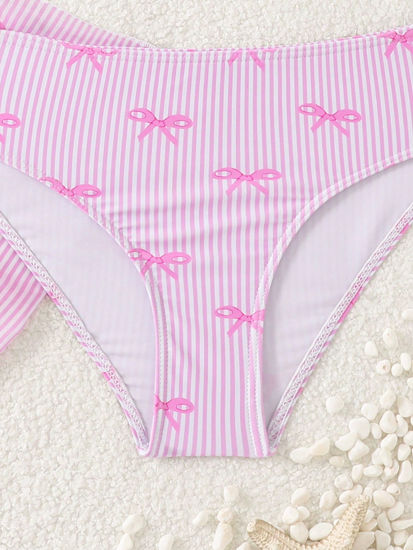Tween girls three-piece bikini set featuring a bow print bandeau-style top, matching mid-waist bikini bottom, and a sheer mesh cover skirt in a cute beachwear style.