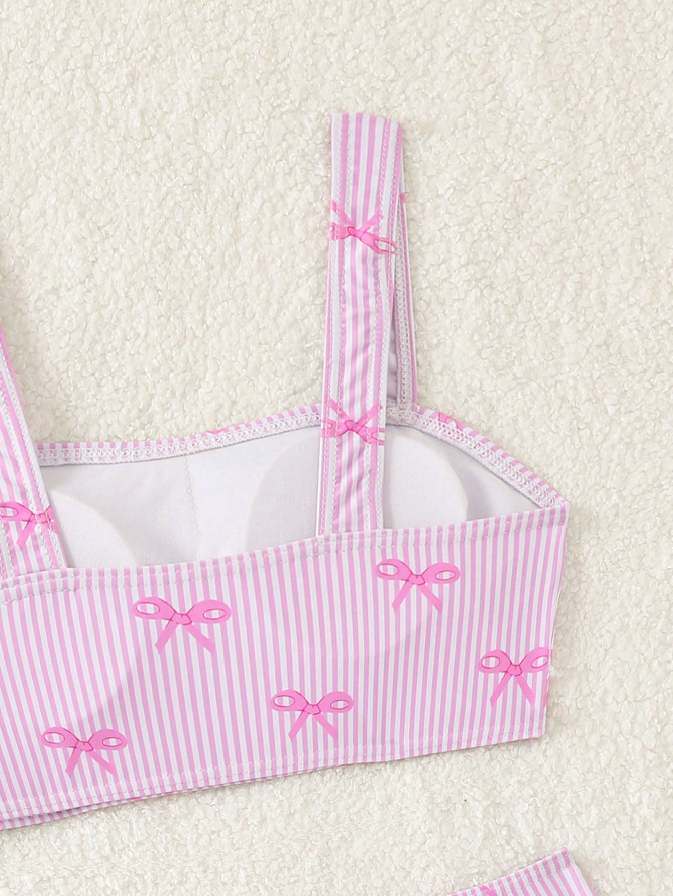 Tween girls three-piece bikini set featuring a bow print bandeau-style top, matching mid-waist bikini bottom, and a sheer mesh cover skirt in a cute beachwear style.