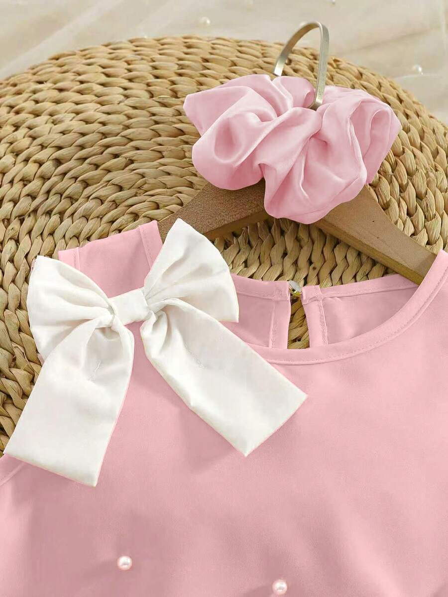 Yellow sleeveless colorblock dress for girls featuring a round neck, ruffle hem, and front bow detail.