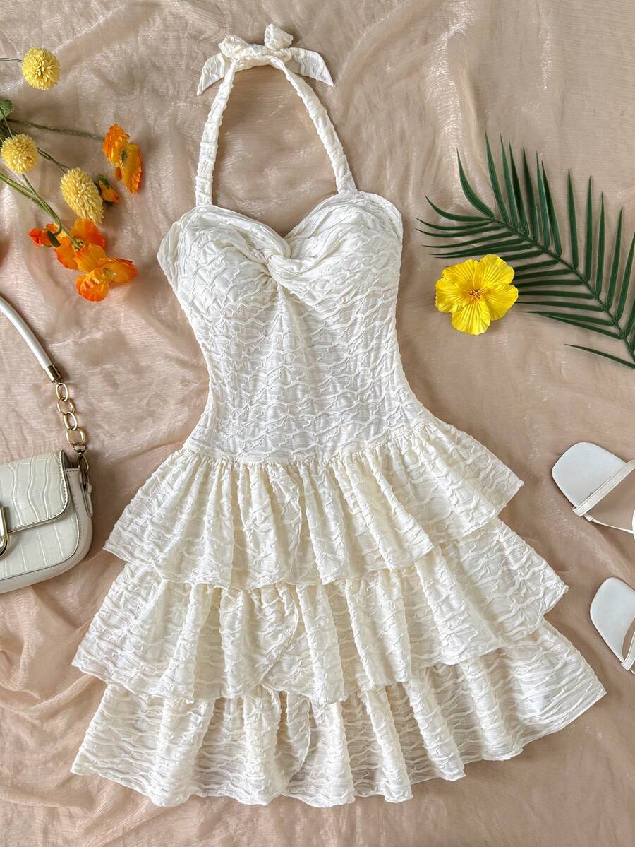 Beige tween girls halter dress with textured jacquard fabric, plant pattern, shirred detail, zipper closure, and layered tiered ruffle hem for vacation wear