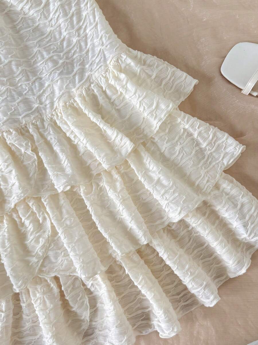 Beige tween girls halter dress with textured jacquard fabric, plant pattern, shirred detail, zipper closure, and layered tiered ruffle hem for vacation wear